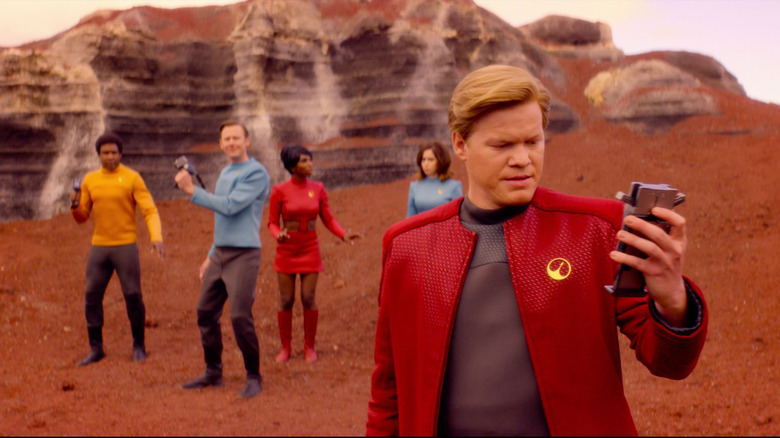 Robert Daly looking at transponder with crew behind him