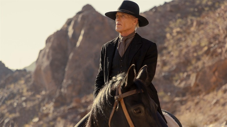 The Man in Black in a black cowboy hat and frock coat, sitting on a dark horse