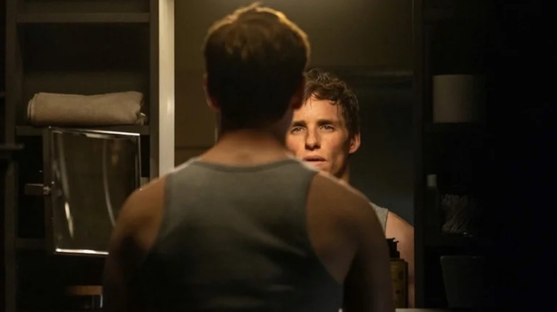 Eddie Redmayne as The Jackal looking at his reflection in The Day of the Jackal