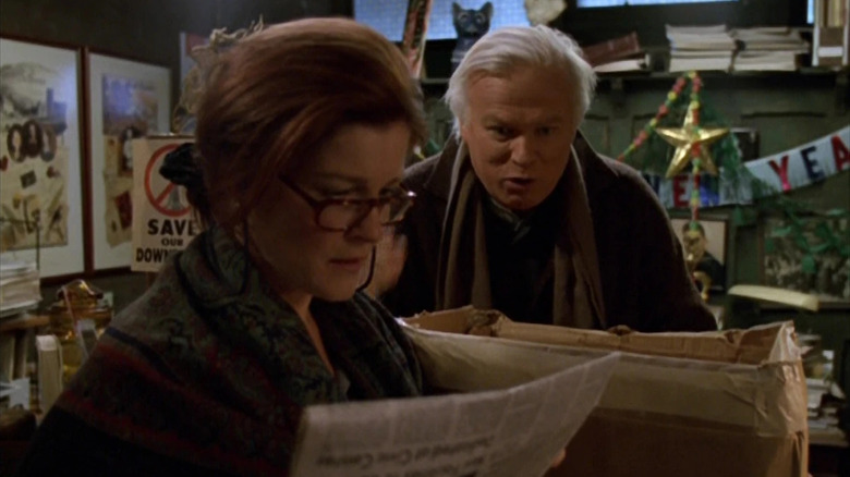 Shannon O'Donnell (Kate Mulgrew) reads a newspaper with Henry Janeway (Kevin Tighe) speaking to her in Star Trek: Voyager