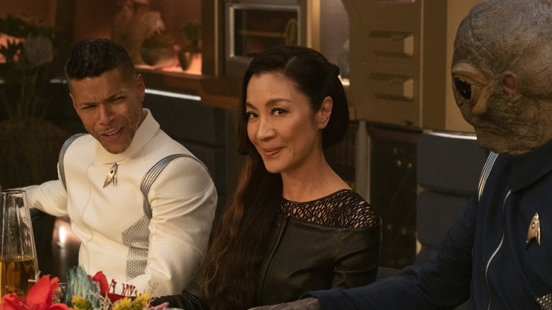 Hugh Culber (Wilson Cruz) and an alien look incredulously at a smirking Philippa Georgiou (Michelle Yeoh) in Star Trek: Discovery