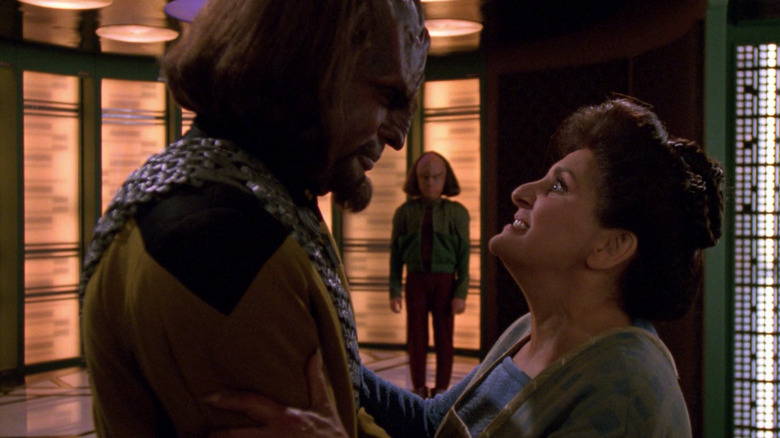 Worf (Michael Dorn) speaks with Helena Rozhenko (Georgia Brown) with Alexander (Brian Bonsall) in the background in Star Trek: The Next Generation