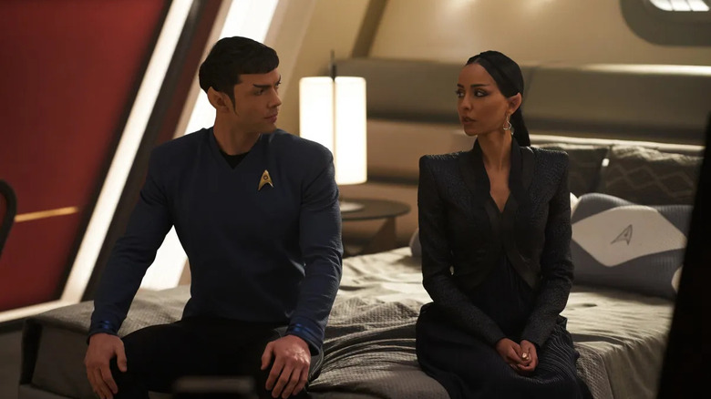 Spock (Ethan Peck) and T'Pring (Gia Sandhu) look at each other cautiously while sitting on a bed in Star Trek: Strange New Worlds