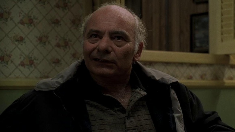Burt Young as Bobby Baccalieri Sr. sits at a table in The Sopranos.