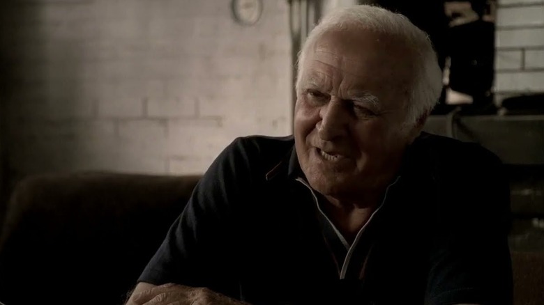 Robert Loggia as Feech La Manna, sitting in a both in The Sopranos.