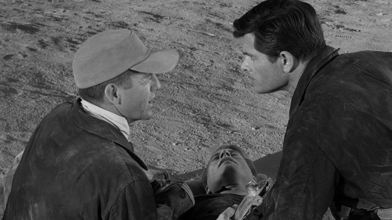 Donlin and Corey speaking beside a fallen man