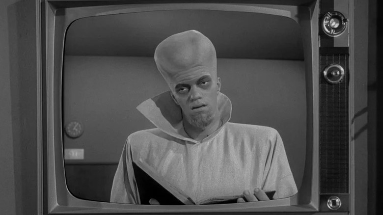 Kanamit, on TV, holding a book