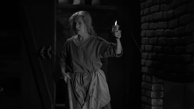An old woman holds a candle in The Twilight Zone