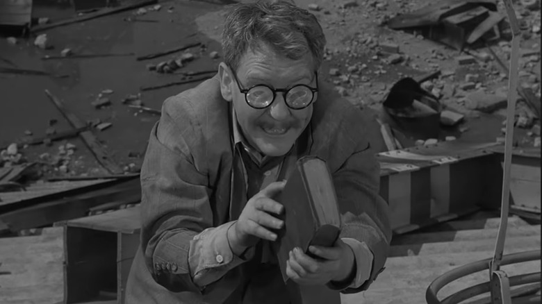 Henry Bemis looks at a book in The Twilight Zone