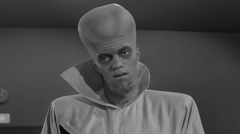 A large headed alien stares off in The Twilight Zone