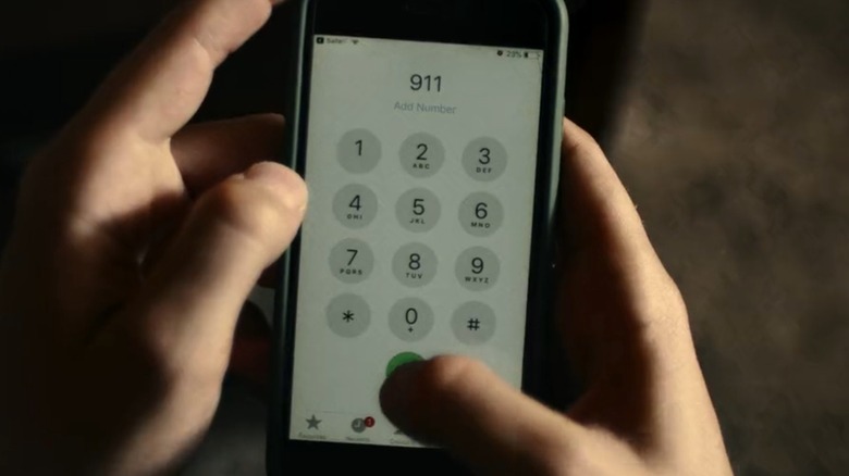 A point-of-view shot of hands holding a cell phone that's dialing 911, from American Nightmare