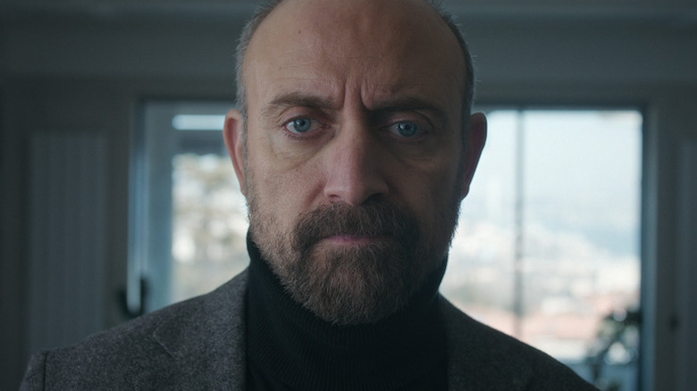 Cem looking serious as he looks on