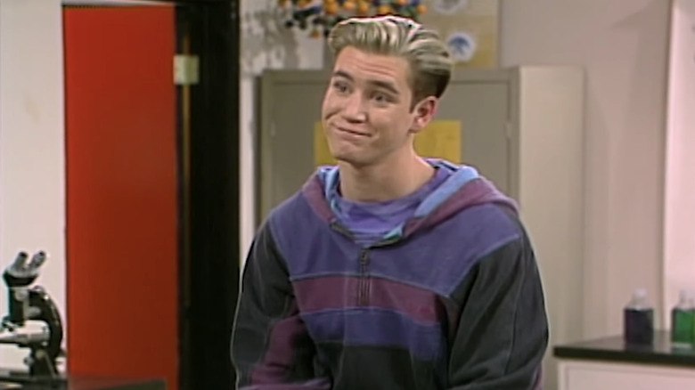 Mark-Paul Gosselaar as Zack Morris sits in a classroom in aved by the Bell