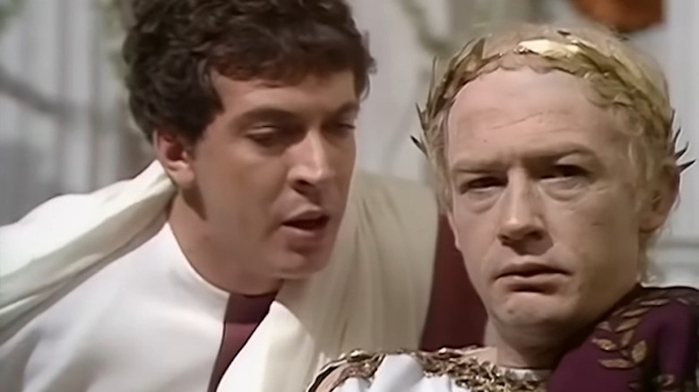 John Castle as Postumus in white toga talking to John Hurt as Caligula in gold crown in I, Claudius.