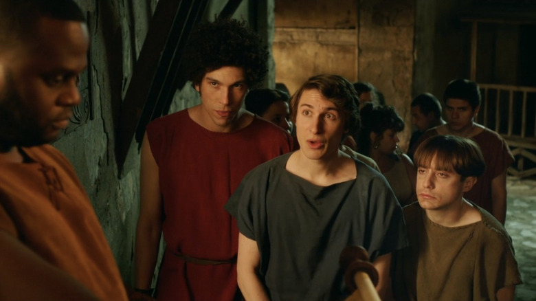 Joel Fry as Stylax, Tom Rosenthal as Marcus, and Ryan Sampson as Grumio wearing ancient Roman attire in Plebs.