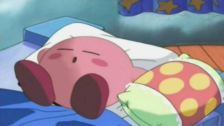 Kirby sleeping on a bed next to a pillow in Kirby Right Back at Ya!