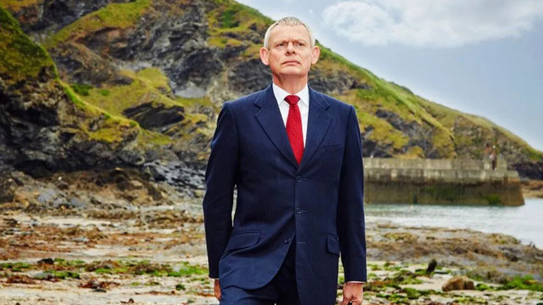 Martin Ellingham (Martin Clunes) stands by a rocky beach in Doc Martin