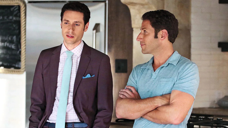 Hank Lawson (Mark Feuerstein) glances at Evan Lawson (Paulo Costanzo) in a kitchen in Royal Pains