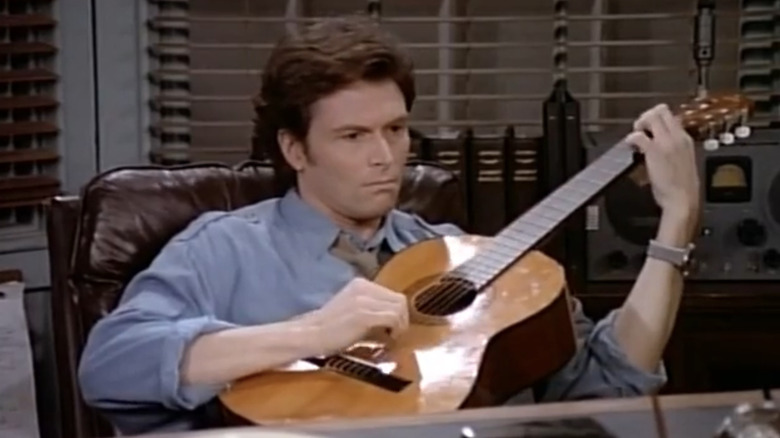 Tim Daly as Joe Hackett plays a guitar on Wings