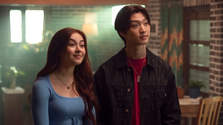 Kitty Song-Covey (Anna Cathcart) and Min-ho Moon (Sang Heon Lee) stand expectantly next to each other in XO, Kitty