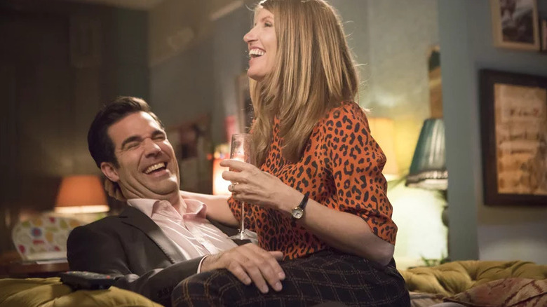 Sharon Morris (Sharon Horgan) laughs while sitting on the lap of Rob Norris (Rob Delaney) in Catastrophe