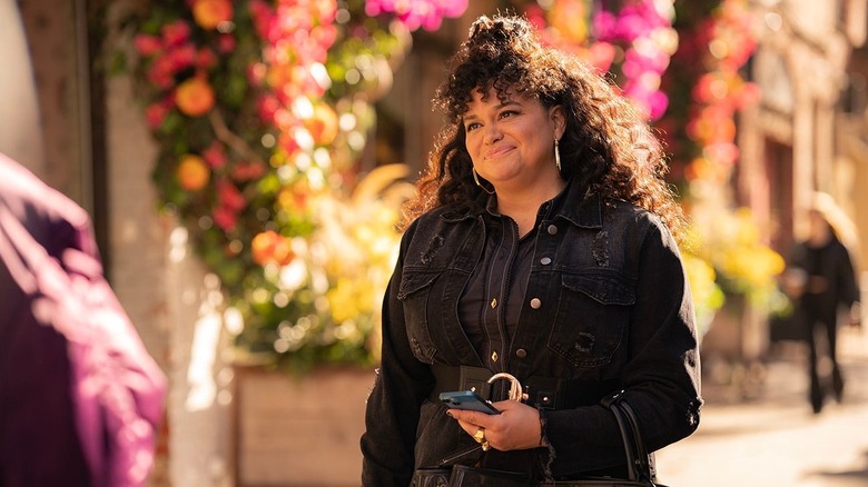 Mavis Beaumont (Michelle Buteau) smiles standing on the sidewalk in Survival of the Thickest