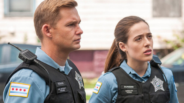Sean Roman and Kim Burgess standing in uniform and looking on