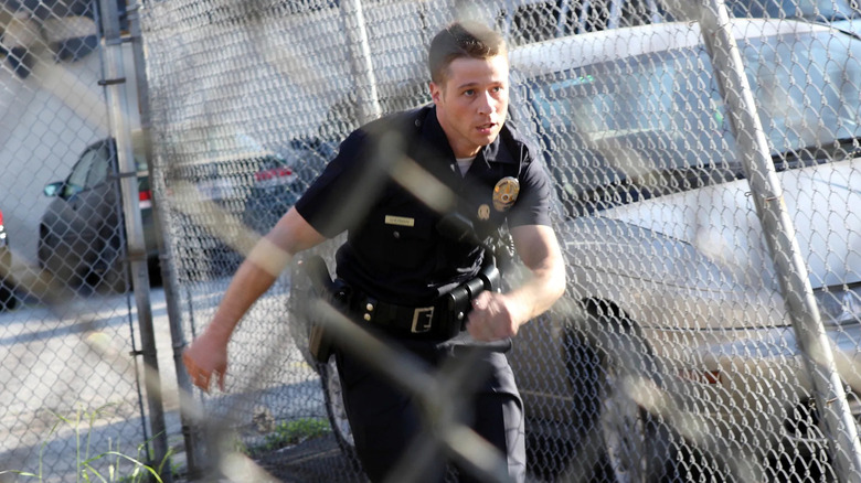Ben Sherman sprinting by a chain-linked fence