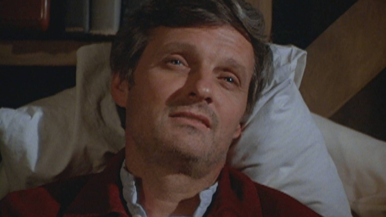 Alan Alda as Hawkeye lying in bed in M*A*S*H