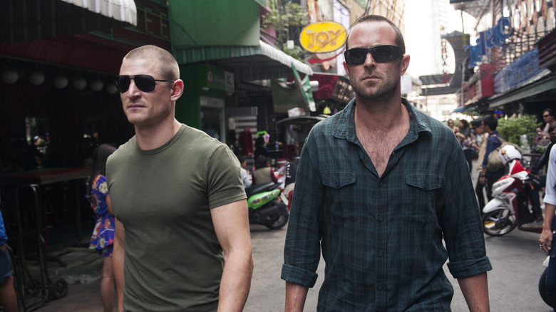 Damian Scott and Michael Stonebridge walking down a city street with sunglasses on