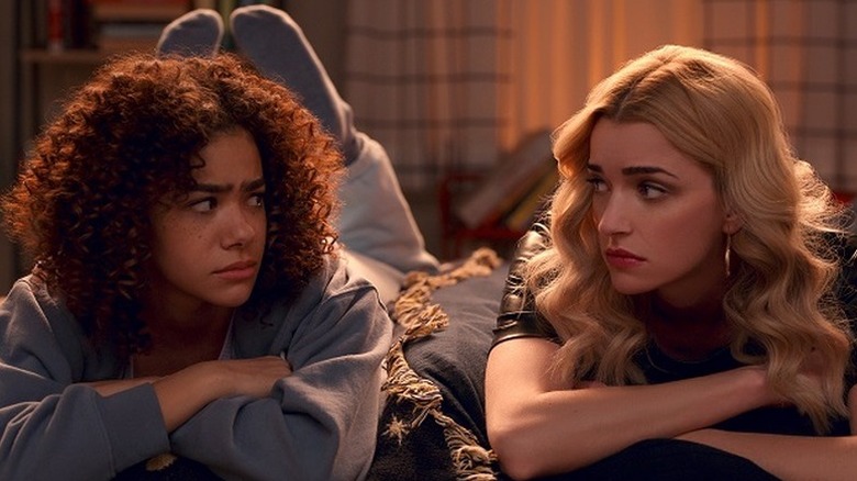 Antonia Gentry as Ginny laying on stomach next to Brianne Howey as Georgia in Ginny & Georgia