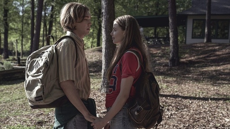 Charlie Plummer as Miles holding the hand of Kristine Froseth as Alaska in front of woodsy cabin in Looking for Alaska