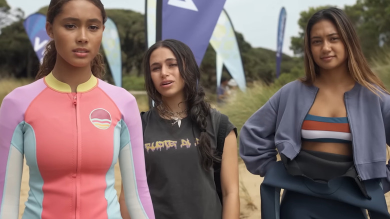 Savannah La Rain as Bodhi, Sky Katz as Summer, and Lilliana Bowrey as Poppy standing on beach in Surviving Summer