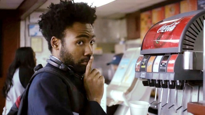 Earn Marks (Donald Glover) shushes next to a soda fountain in Atlanta