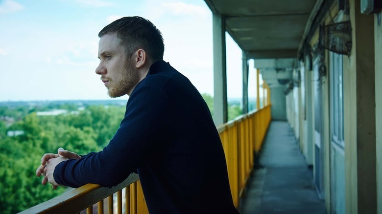 Sean Finn (Joe Cole) stands overlooking the city from a railing in Gangs of London