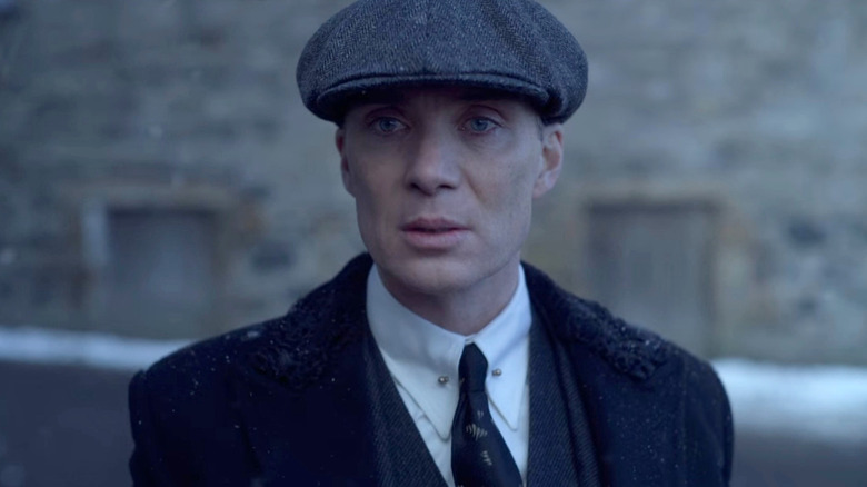 Tommy Shelby (Cillian Murphy) stands outside in the rain in Peaky Blinders