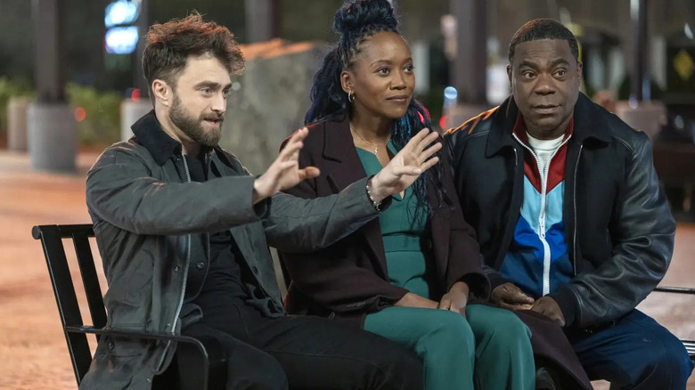 Arthur Tobin (Daniel Radcliffe) explains something to Monica (Erika Alexander) and Reggie Dinkins (Tracy Morgan) in The Fall and Rise of Reggie Dinkins