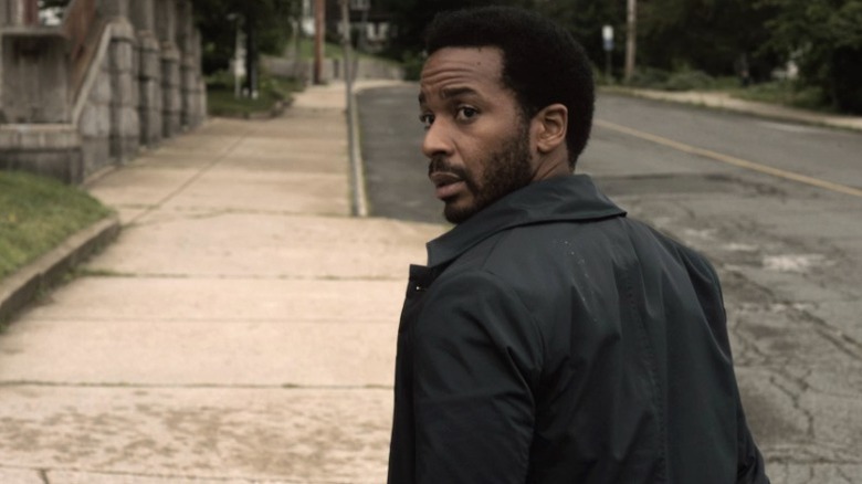 Henry (André Holland) walking down the street and looking back over his shoulder on Castle Rock S1E1