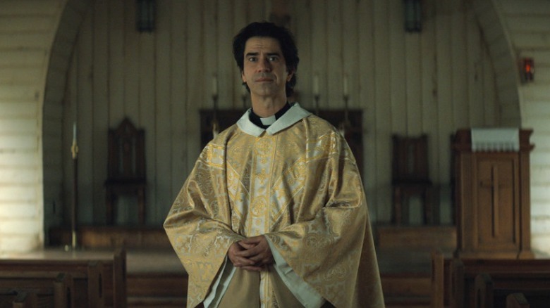 Father Paul (Hamish Linklater) standing in the middle of the church on Midnight Mass S1E1