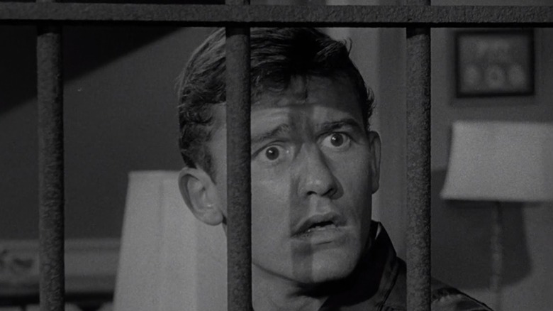 Sam Conrad (Roddy McDowall) stares in shock through bars in his window in "The Twilight Zone."