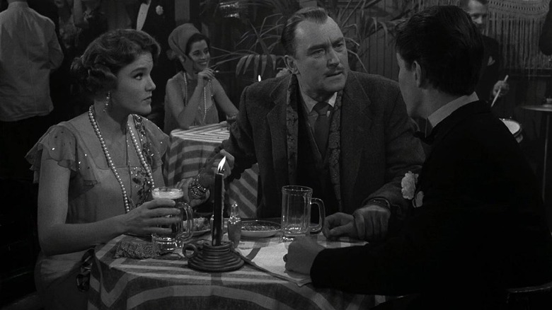 Laura Templeton (Pippa Scott) and Booth Templeton (Brian Aherne) sit at a table speaking with another in The Twilight Zone (1959)