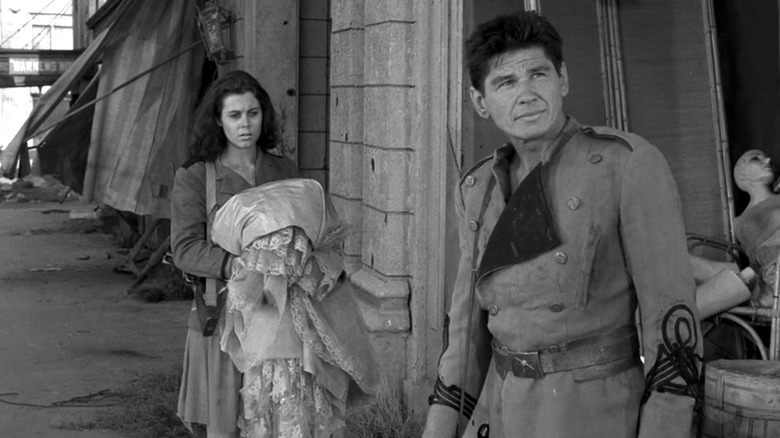 Elizabeth Montgomery and Charles Bronson's unnamed characters standing on a ravaged street on "The Twilight Zone."