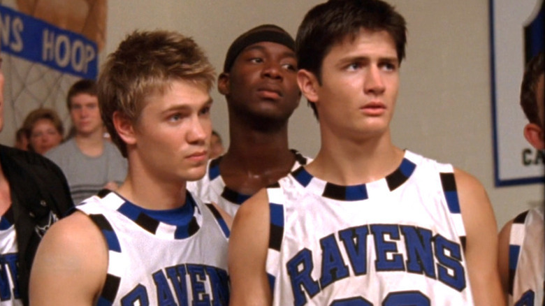 Lucas in blue and white basketball uniform standing next Nathan in same uniform
