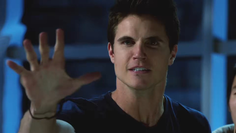 Robbie Amell as Stephen Jameson holding up his hand in The Tomorrow People