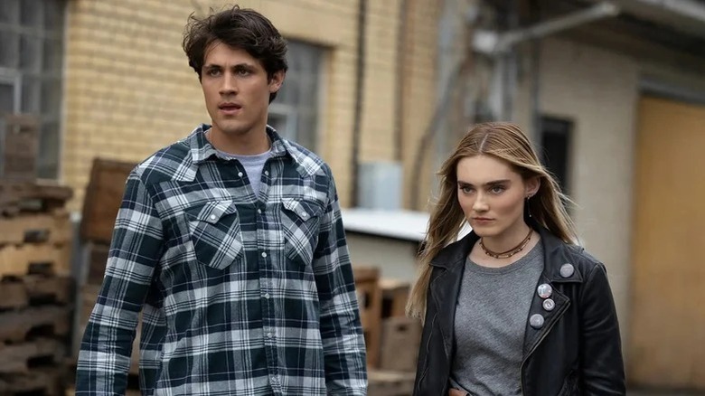 Drake Rodger as John Winchester and Meg Donnelly as Mary Campbell standing together in The Winchesters