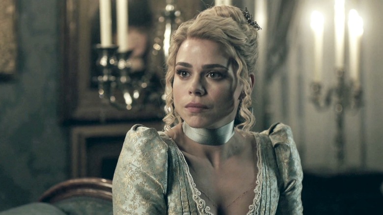 Brona Croft in a teal dress, seated at a table