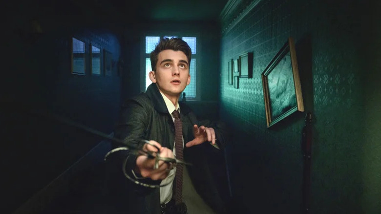 Anthony Lockwood (Cameron Chapman) draws a sword in an eerie hallway in Lockwood & Co.