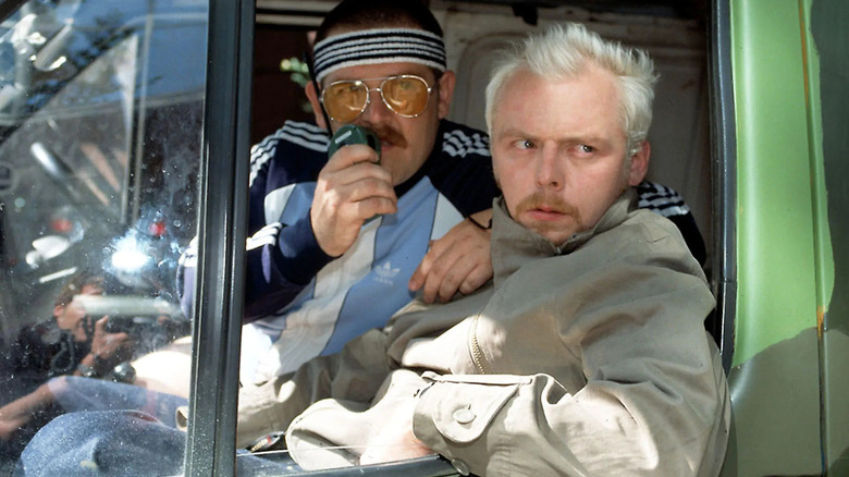Mike Watt (Nick Frost) speaks on a walkie-talkie while seated in a van with Tim Bisley (Simon Pegg) in Spaced