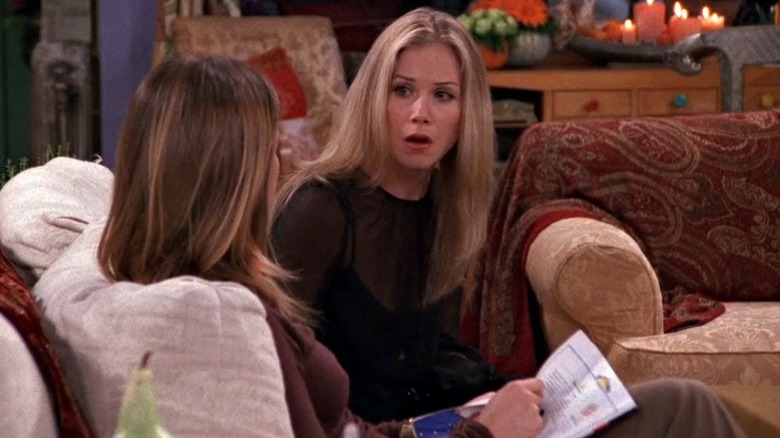 Amy sitting on a couch next to Rachel in Friends