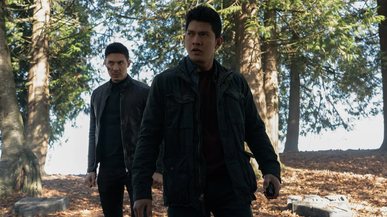Lu Xin Lee (Lewis Tan) and Kai Jinn (Iko Uwais) stand in a forest in Wu Assassins